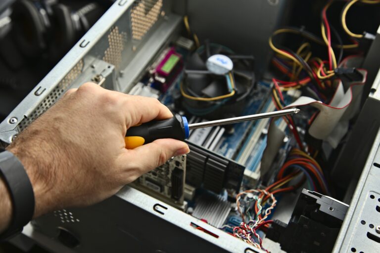 A technician repairing a desktop computer. This image has selective focus.